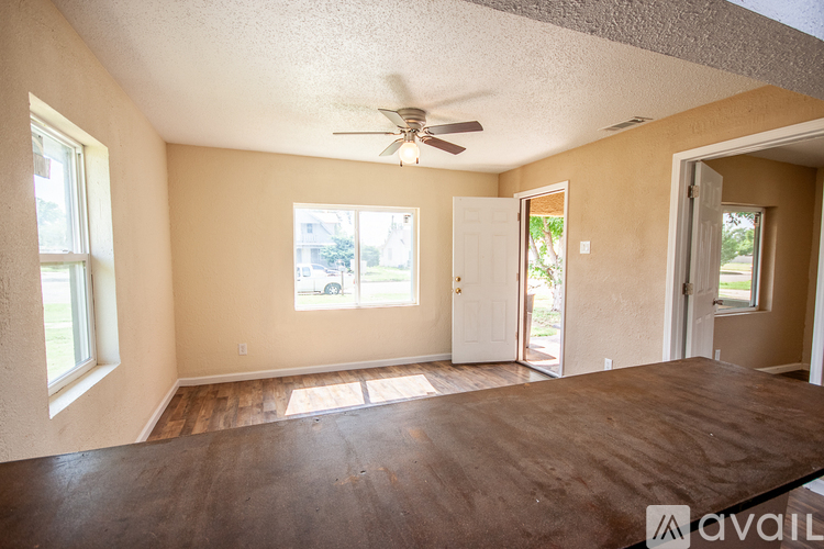 A room with a ceiling fan and wooden flooring.