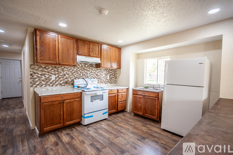 A kitchen with wooden cabinets and a white refrigerator.