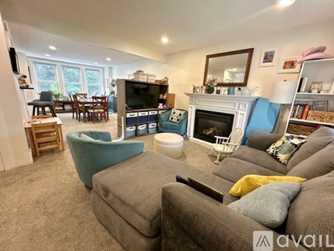 A living room with a grey couch and a fireplace.