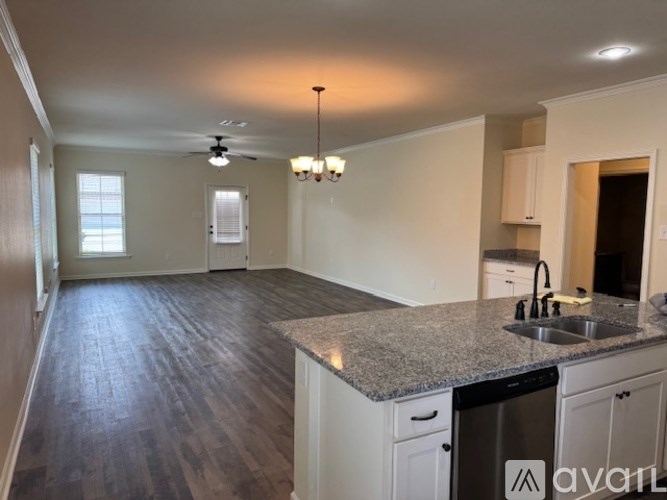 A kitchen with a sink, stove, and cabinets.