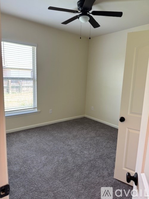 A room with a ceiling fan and a door.