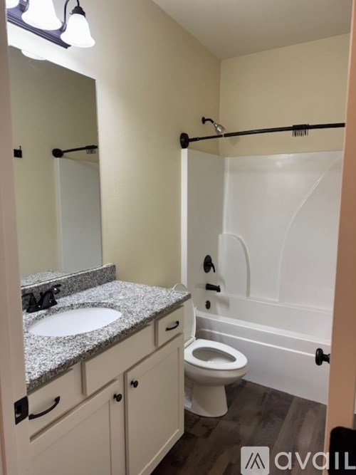 A bathroom with a toilet, sink, and a shower.