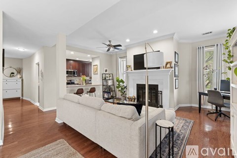 A living room with a white couch and a fireplace.