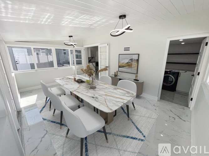 A modern dining room with a marble table and chairs.