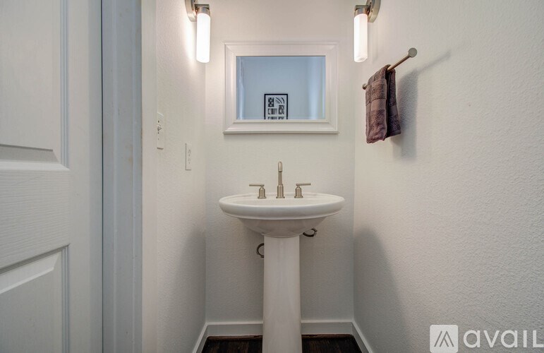 A small white sink in a small bathroom.