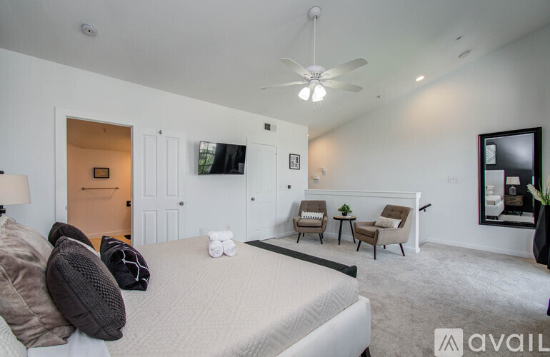 A bedroom with a large bed and a ceiling fan.