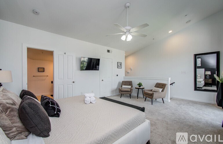 A bedroom with a large bed and a ceiling fan.