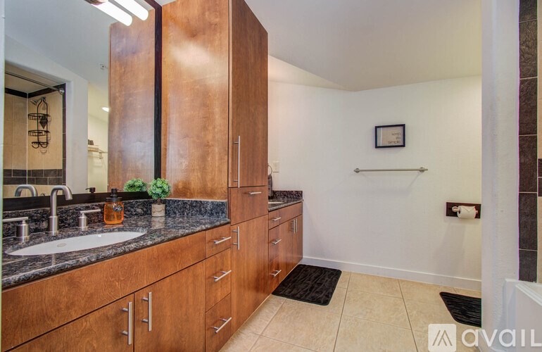 A bathroom with a sink, mirror, and wooden cabinets.