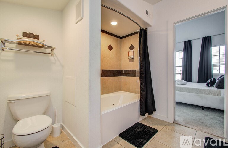 A bathroom with a toilet, a bathtub, and a window.