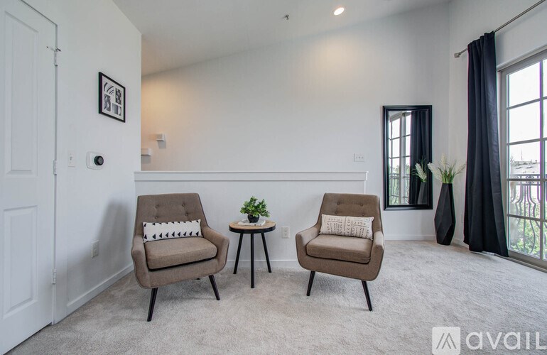 Two chairs and a small table are in a room with a window.