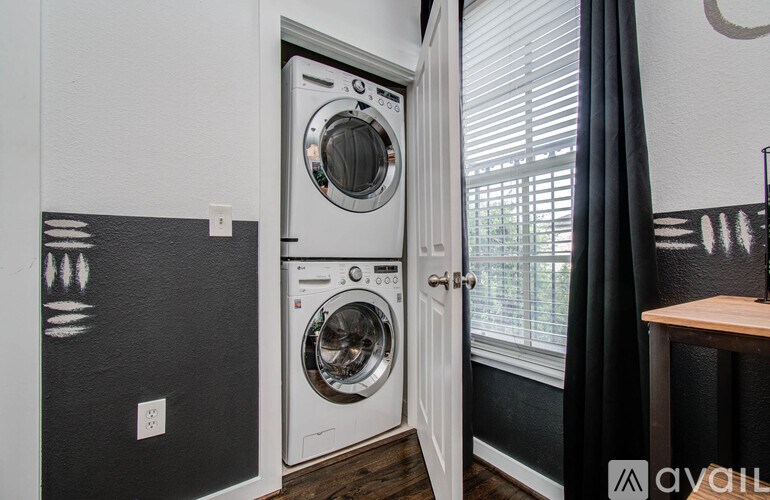 A white washing machine is in a small laundry room.