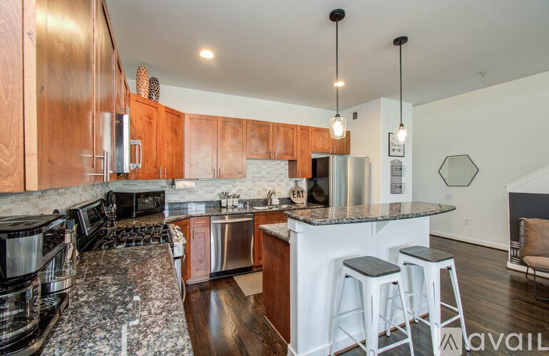 A kitchen with a granite countertop and stainless steel appliances.