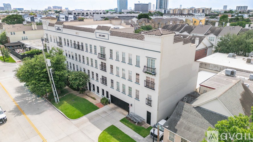 A white building with a green lawn in front of it.