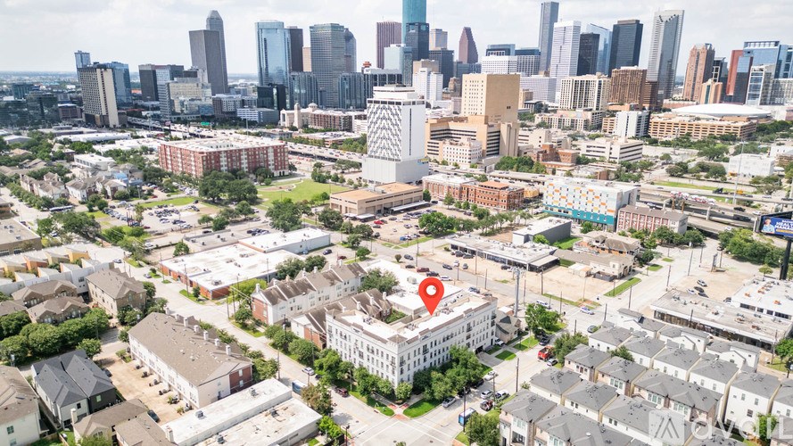 A cityscape with a red pin on a building in the foreground.