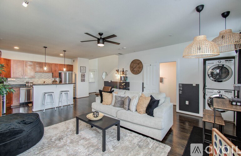 A living room with a white couch and a black coffee table.