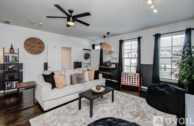 A living room with a white couch, a coffee table, and a ceiling fan.
