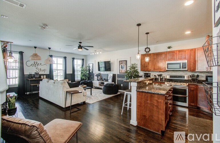 A modern open plan living and kitchen area with wooden floors and furniture.