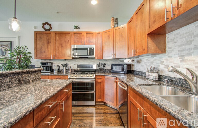 A kitchen with wooden cabinets and granite countertops.