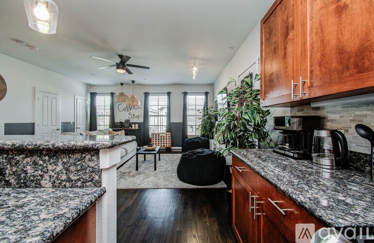 A kitchen with a granite countertop and wooden cabinets.