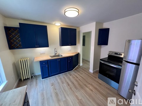 A kitchen with blue cabinets and a wooden floor.