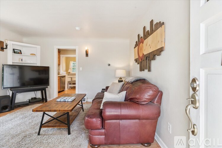 A living room with a red leather couch and a wooden coffee table.