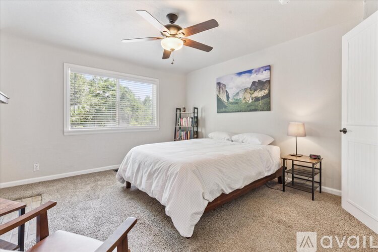 A bedroom with a large bed and a ceiling fan.