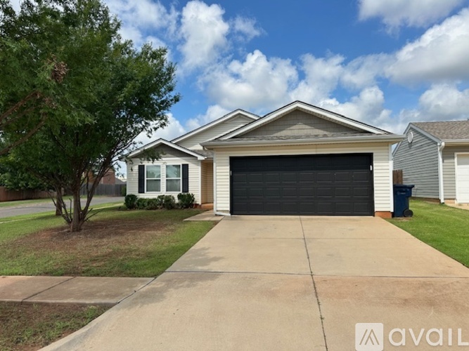 A house with a garage and a driveway in front.