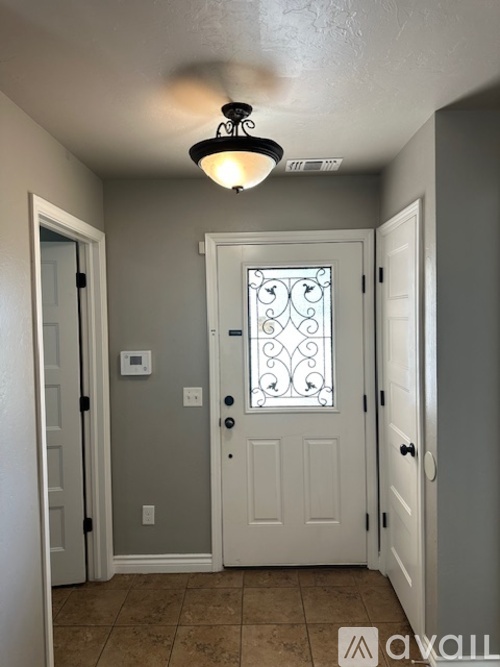 A hallway with a white door and a light on the ceiling.