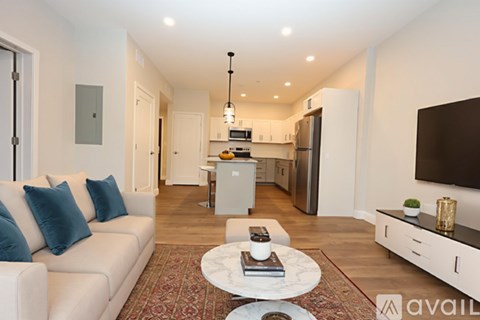 A living room with a white couch and a coffee table in the middle.