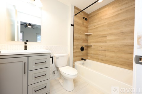 A bathroom with a toilet, sink, and bathtub.