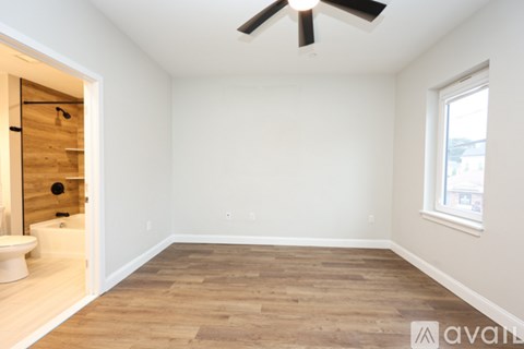 A room with wooden flooring and a ceiling fan.
