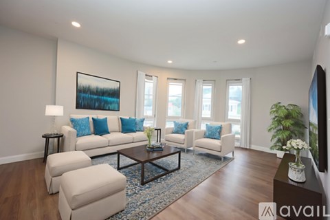 A living room with a white couch, a coffee table, and a painting on the wall.