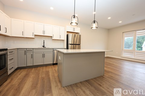 A kitchen with wooden floors and a large island in the middle.