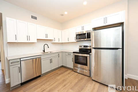 A kitchen with stainless steel appliances and white cabinets.