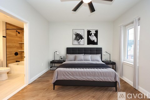 A bedroom with a bed, nightstands, and pictures on the wall.