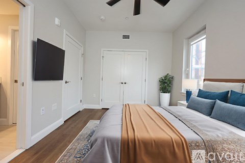 A bedroom with a large bed and a flat screen TV.