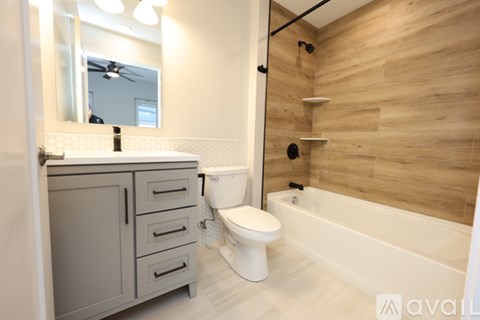 A bathroom with a wooden wall and a white bathtub.