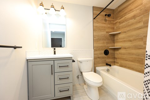 A bathroom with a white toilet and a wooden wall.