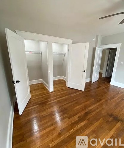 A room with white doors and wooden floors.