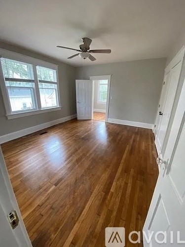 A room with wooden floors and a ceiling fan.