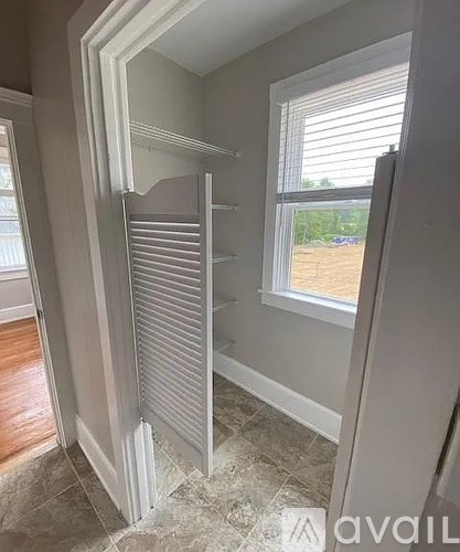 A white closet with a sliding door is open.