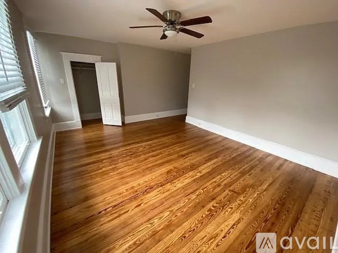 A room with wooden flooring and a ceiling fan.