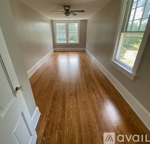 A room with wooden flooring and a ceiling fan.