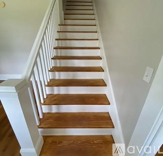 A set of wooden stairs with white balusters.