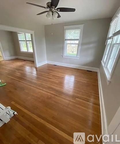 A room with wooden floors and a ceiling fan.