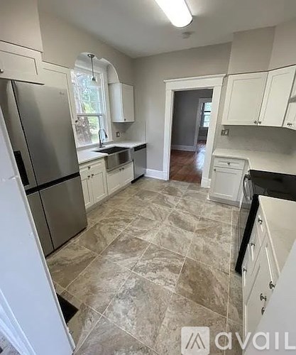A kitchen with tile flooring and white appliances.