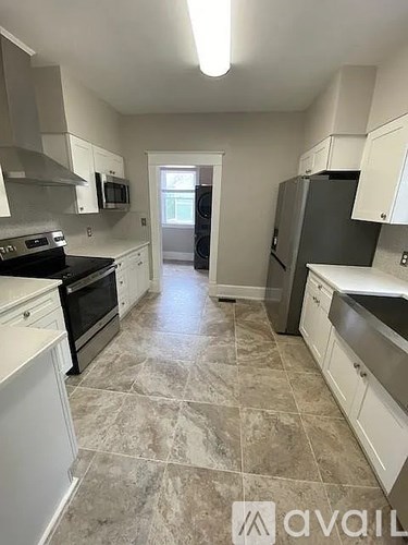A kitchen with white cabinets and a tiled floor.