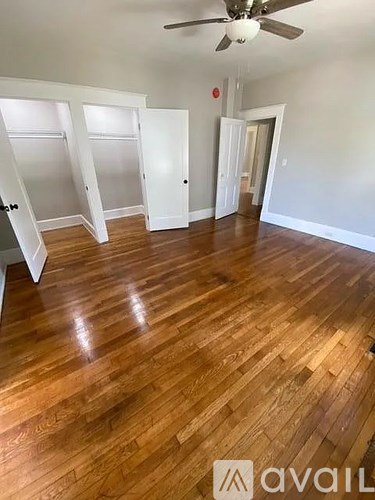 A room with wooden flooring and a ceiling fan.