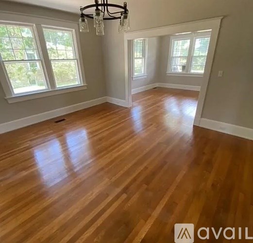 A room with wooden flooring and a chandelier.
