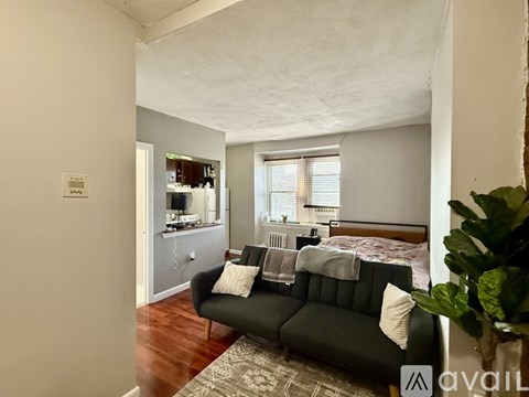 A living room with a black couch and a television.